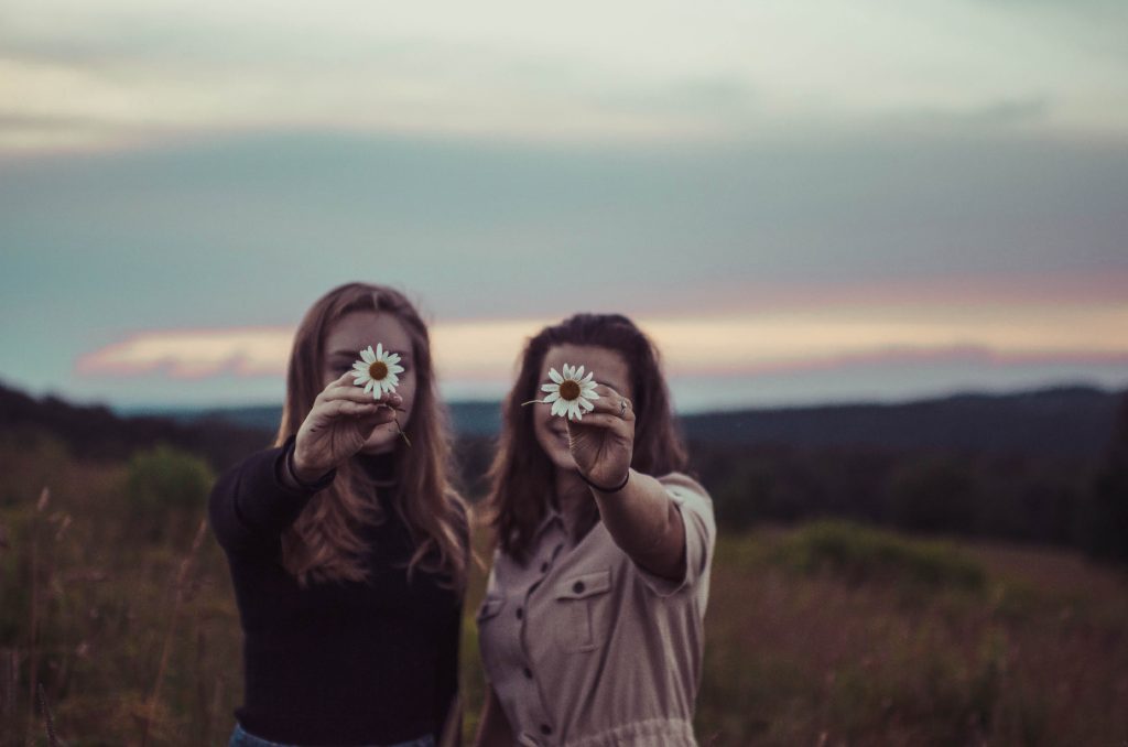 Funny friendship day quotes for you to enjoy with your bffs-two girls holding flower.