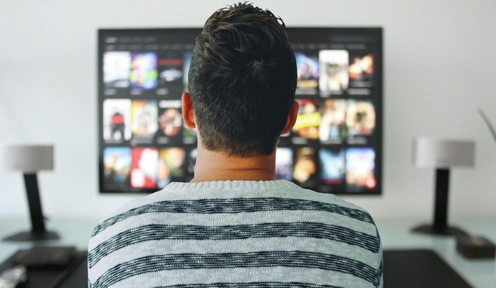 man watching TV screen